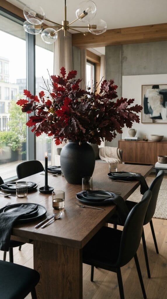 16 Fall Centerpiece Ideas for Your Dining Table 17 A matte black ceramic vase holding dark burgundy branches on a table.